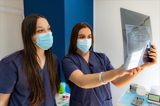 Two dentists experienced in the X-ray examination of a human jaw in the dental office