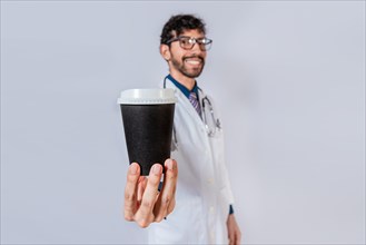 Smiling doctor showing coffee to go isolated. Friendly doctor showing coffee to go isolated