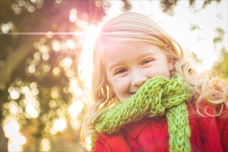 Little girl wearing winter coat and scarf at the park