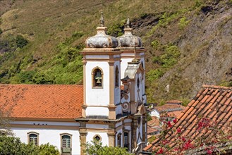 Side view of historic church in baroque and colonial style from the 18th century amid the hills and vegetation of the city Ouro Preto in Minas Gerais