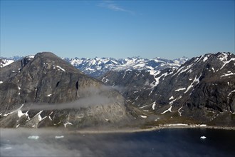 View over rugged snow-capped mountain landscapes and fjord