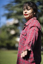 Portrait of andean woman posing in a park. Model striking a pose in a park. Follow me concept