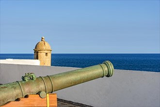 Old iron cannon and guardhouse on the strong walls of the historic fortress of Farol da Barra in the city of Salvador