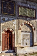 Facade of ancient sunlit mosque with its colorful frescoes and reliefs in the city of Istanbul in Turkey