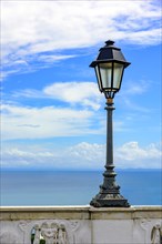 Urban Lampposts on ancient wall with the sea in the background in the city of Salvador