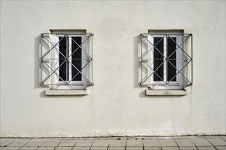 Two barred windows in a house wall