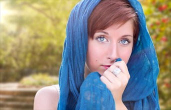 Pretty blue eyed young red haired adult female outdoor portrait