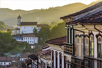 View of historic colonial style houses and church in the background on the hills of Ouro Preto city