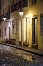 Old cobblestone street with lantern-lit colonial houses at night in the Pelourinho neighborhood of Salvador
