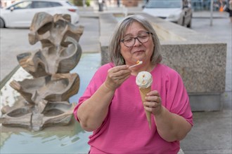 Close-up of a lemon ice cream in the background a woman with white hair and glasses out of focus