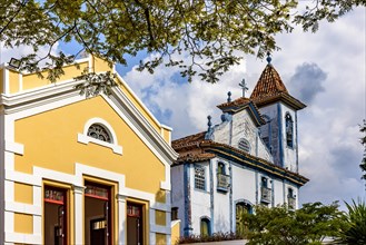 Historic baroque church next to a neoclassical building lit by the afternoon sun in the city of Diamantina in Minas Gerais