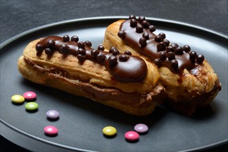 Two chocolate eclairs on a plate