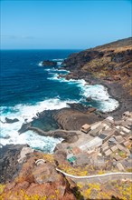 View from above of the fishing village of Pozo de las Calcosas on the island of El Hierro and the cliffs. Canary Islands