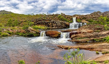 Panoramic image of set of clear water waterfalls among the rocks and native vegetation of the Biribiri environmental reserve in Diamantina