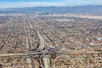 Aerial view of Harbor interchange and Century Freeway traffic with downtown Los Angeles