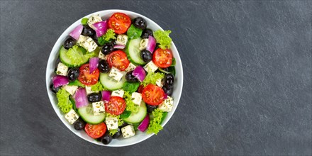 Greek salad with fresh tomatoes olives and feta cheese healthy eating food from above on slate banner with text free space in Stuttgart