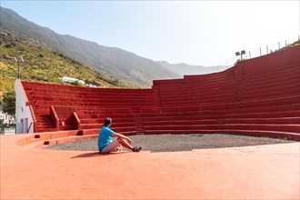 A tourist visiting the amphitheater next to the Nuestra Senora de Candelaria church in La Frontera on El Hierro