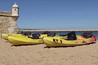 Kayaks on the sandy beach next to the Forte da Ponta da Bandeira