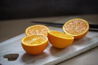 Delicious juicy oranges lie sliced on a wooden board