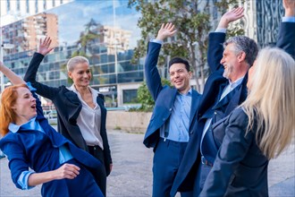 Senior Executives Encourage Each Other with High-Five in Teamwork and Goal Achievement