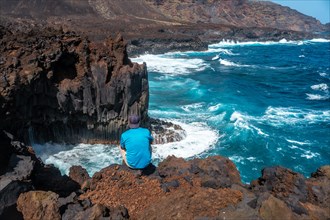 A young man on the volcanic trail in the town of Tamaduste on the coast of the island of El Hierro