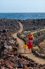 Walking on the volcanic path in the town of Tamaduste on the coast of the island of El Hierro