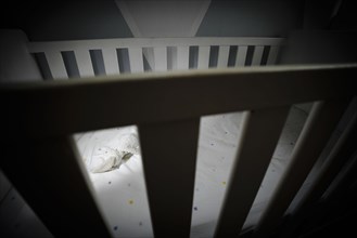 Symbolic photo on the subject of child abuse. A stuffed animal lies in an empty cot. Berlin