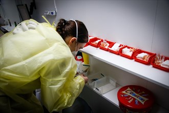An employee checks mounted syringes of the BioNTech Pfizer vaccine at a COVID-19 vaccination and testing centre at Autohaus Olsen in Iserlohn