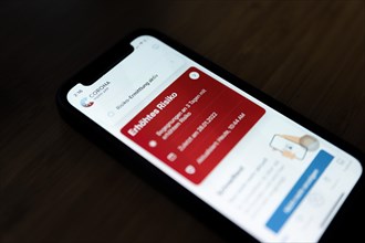 A red Corona Warn app indicates an increased risk of infection with Covid-19 coronavirus on an iPhone 12 Mini in Berlin