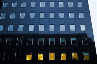 Symbolic photo on the subject of empty office space. Dark office spaces are seen in a street in Berlin Mitte in the early morning. Berlin