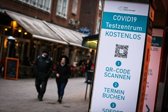 Passers-by pass a COVID-19 test centre in the old town of Duesseldorf