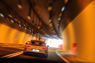 Sports car High-horsepower Porsche 911 GT3 speeder drives slowly fast speeds through road tunnel Tunnel