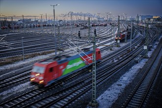 An electric locomotive of DB Cargo runs through the freight station Halle