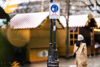 A sign indicating that masks are compulsory stands out at the Christmas market on Breitscheidplatz in Berlin