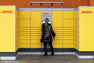 A woman stands at a DHL parcel station in Berlin