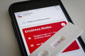 A negative rapid test is on a smartphone on which the Corona Warn app displays the words Increased Risk. Berlin