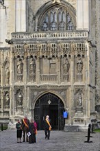 Tour guides wearing orange sashes leaving the Canterbury Cathedral in Canterbury