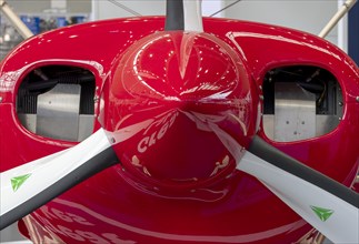 The front part of the aircraft with the propeller with red engine cowling and engine cooling vents