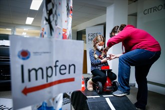 A girl is vaccinated by a doctor with the BioNTech Pfizer children's vaccine at a COVID-19 vaccination and testing centre at the Olsen car dealership in Iserlohn