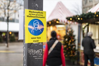 A sign indicating that masks are compulsory stands out at the Christmas market on Alexanderplatz in Berlin