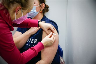 A woman is vaccinated by a doctor with the BioNTech Pfizer vaccine at a COVID-19 vaccination and testing centre at Autohaus Olsen in Iserlohn