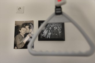 Symbolic picture on the subject of a nursing home. Family pictures in front of an upright hanger in a nursing home.