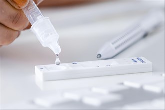 Symbol photo on the topic ' Compulsory testing in the office '. A Sars Covid-19 antigen rapid test lies on the keyboard of a computer. Berlin