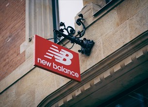 A nose sign of the company New Balance hangs above a shop in Berlin. 02.02.2022.