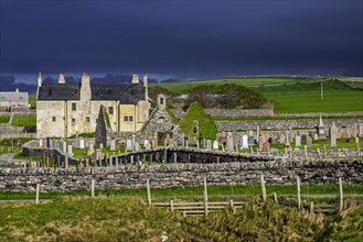Black storm clouds rolling in over ruined church and the Balnakeil House