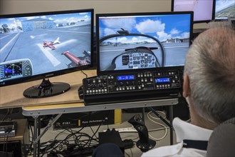 Man navigating virtual airplane in amateur flight simulator