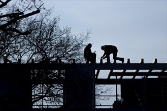 Two craftsmen silhouetted on a building site in Berlin