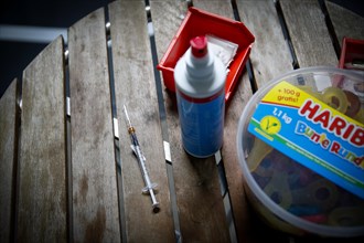 A syringe infused with BioNTech Pfizer children's vaccine lies on a table next to a pack of Haribo sweets at a COVID-19 vaccination and testing centre at Autohaus Olsen in Iserlohn