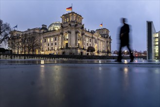 A person silhouetted in front of the German Bundestag at the Spreebogen in Berlin