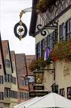 Late medieval townscape with hotel and nose sign